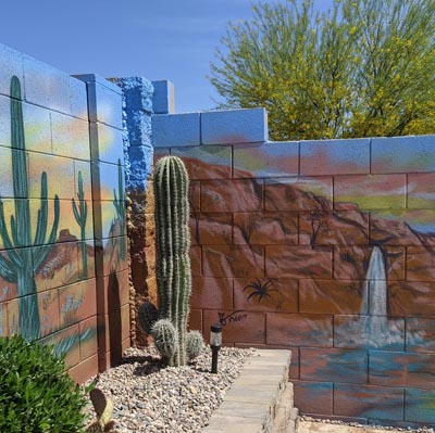 Custom backyard mural of a pink and purple Arizona desert sunset with cacti.