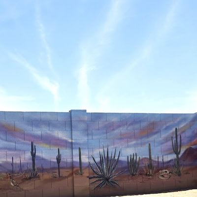Glowing orange sunset landscape mural featuring saguaro cacti.