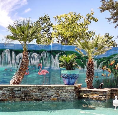 Vibrant tropical backyard mural featuring pink flamingos by the pool.